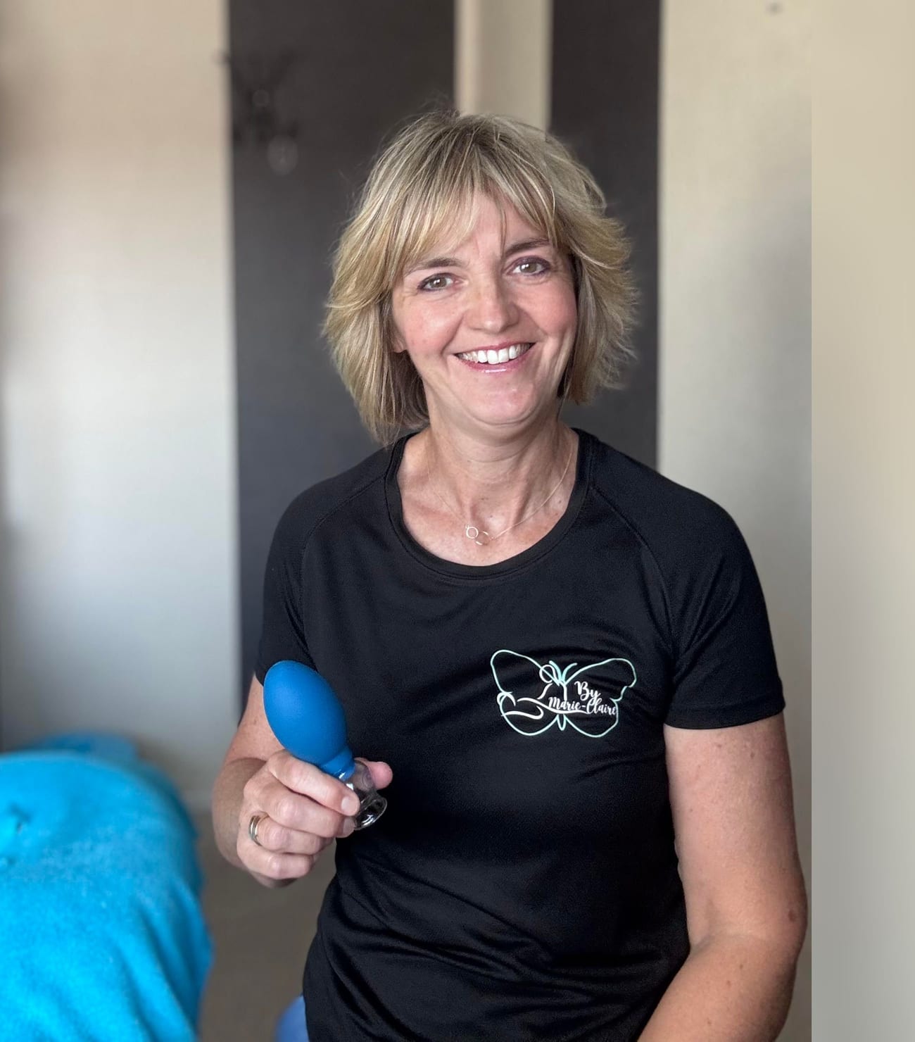 Marie-Claire in haar behandelruimte met een blauwe cup in haar hand