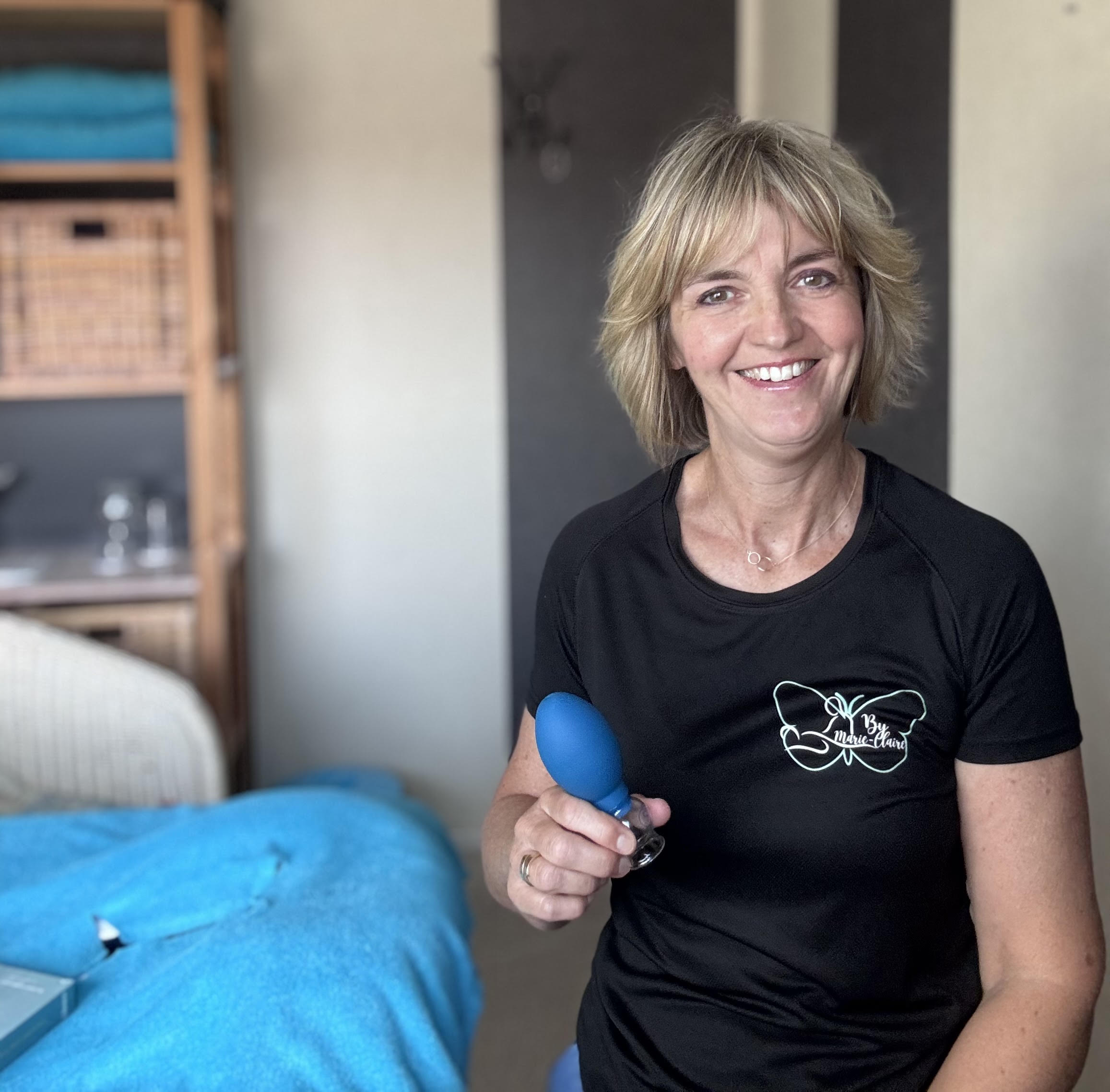 Marie-Claire Lucas met een cup in haar hand in haar praktijk